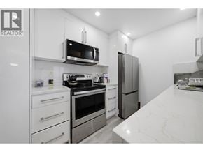 North Vancouver apartment for rent - A modern kitchen with stainless steel appliances and white cabinetry.