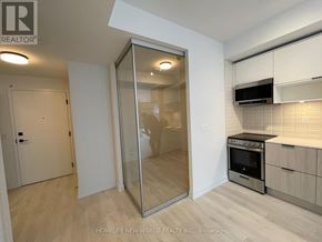 Toronto (Waterfront Communities) condo for rent - A modern kitchen with a glass door cabinet and stainless steel appliances.