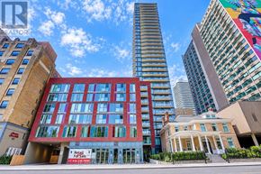 Toronto (Church-Yonge Corridor) condo for rent - A tall building with a red sign in front of it.