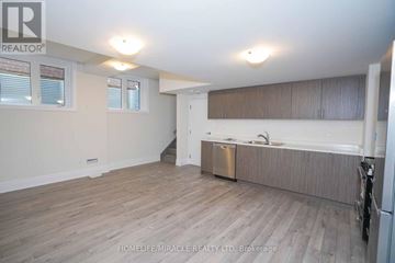 Barrie (Innis-Shore) apartment for rent - A room with wooden flooring and a kitchen area with a sink and stove.