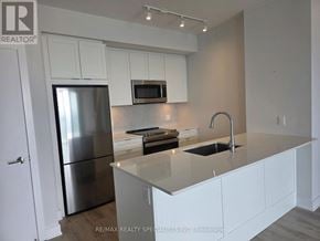 Mississauga (City Centre) condo for rent - A modern kitchen with white cabinets and stainless steel appliances.