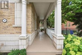 Mississauga (Port Credit) townhouse for rent - A porch with a white railing and a brick wall with a number 36 on it.