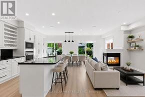 Mississauga (Port Credit) townhouse for rent - A modern kitchen and living room with a fireplace and a dining table.