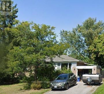 Halton Hills (Georgetown) apartment for rent - A house with a car and a trailer parked in front.
