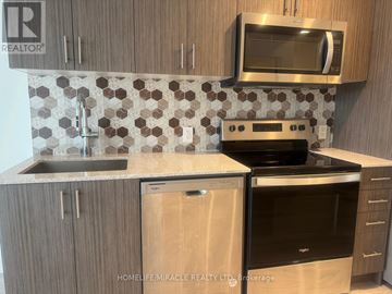 Hamilton (Riverdale) condo for rent - A kitchen with a stove top oven and microwave above it.