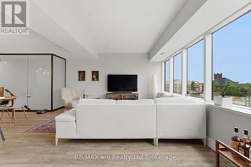 Woodstock (Woodstock - North) apartment for rent - A living room with a white couch and a flat screen TV.