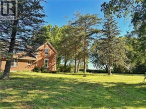 Waterford apartment for rent - A house is surrounded by trees in a grassy field.