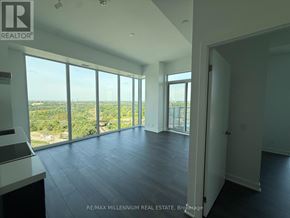 Vaughan (Steeles West Industrial) condo for rent - A spacious room with large windows overlooking a landscape.