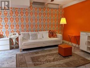 Pickering (Village East) house for rent - A living room with orange walls and a white couch.