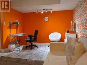 Pickering (Village East) house for rent - A room with orange walls has a clock and a black chair.