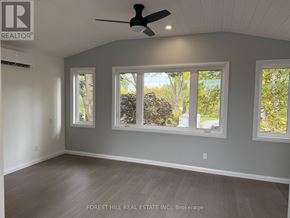 Ramara apartment for rent - A room with a ceiling fan and three windows.