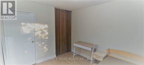 Oakville (Cp College Park) apartment for rent - A room with a white door, a brown wardrobe, a small table and a bench.