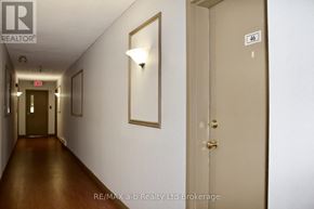Woodstock (Woodstock - North) condo for rent - A hallway with a door numbered 46 and a brokerage logo.