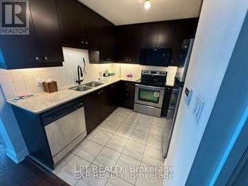 Mississauga (City Centre) condo for rent - A kitchen with dark brown cabinets and a white refrigerator.