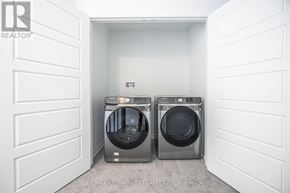 Pickering duplex for rent - A white laundry room with two front loading washing machines.