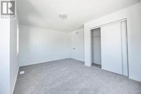 Pickering duplex for rent - A spacious room with white walls and carpeted floor.
