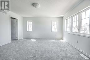 Pickering duplex for rent - A room with a carpet floor and a door on the left.