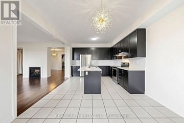 Markham (Berczy) apartment for rent - A modern kitchen with black cabinets and a white island.