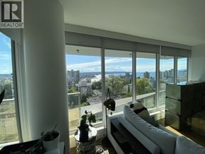 Vancouver apartment for rent - A living room with a large window overlooking a cityscape.