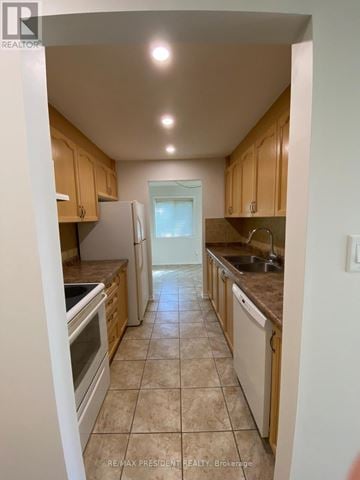 Hamilton (Quinndale) townhouse for rent - A kitchen with wooden cabinets and a tiled floor.