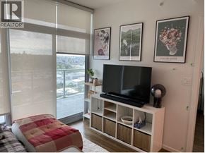 Burnaby apartment for rent - A bedroom with a bed, a tv stand, and pictures on the wall.