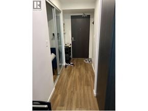 Burnaby apartment for rent - A hallway with a black door and a mirror on the wall.