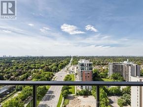 Toronto (Humber Heights) condo for rent - A view from a balcony overlooking a cityscape with buildings and greenery.