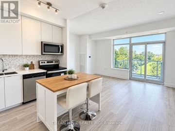 Toronto (Tam O'shanter-Sullivan) condo for rent - A modern kitchen with white cabinets and a wooden island.
