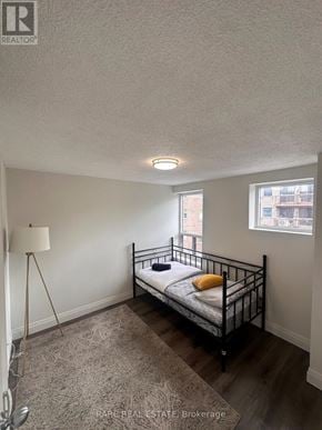 Toronto (Kensington-Chinatown) multi-family for rent - A bedroom with a bed, a floor lamp, and a window.
