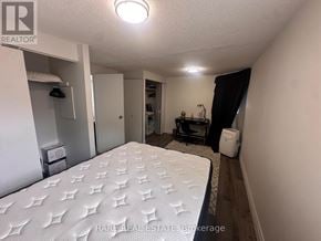 Toronto (Kensington-Chinatown) multi-family for rent - A bedroom with a large bed and a small closet.