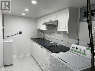 Toronto (Hillcrest Village) apartment for rent - A well-lit kitchen with white cabinets and a black countertop.