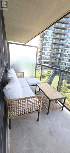 Toronto (Mimico) condo for rent - A balcony with a wicker chair and a small table.