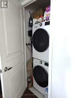 Toronto (Mimico) condo for rent - A white door is open to a small laundry room with a washer and dryer.
