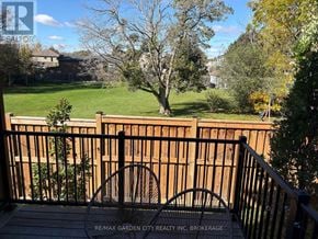 Welland (N. Welland) townhouse for rent - A deck with a railing and a view of a yard and houses.
