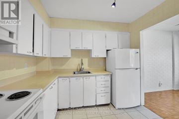 Ottawa condo for rent - A kitchen with white cabinets and appliances.