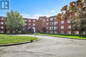 Ottawa condo for rent - A street view of a residential area with apartment buildings and trees.