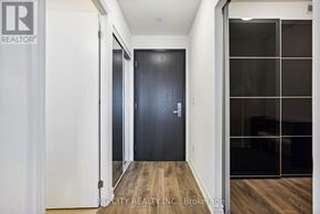 Toronto (Henry Farm) condo for rent - A hallway with a black door and a glass wall on the right side.