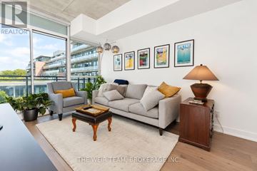 Toronto (South Riverdale) condo for rent - A living room with a grey couch, a coffee table, and a lamp on a side table.