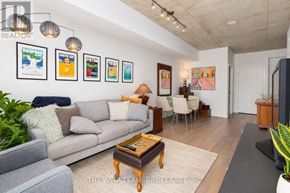 Toronto (South Riverdale) condo for rent - A living room with a grey couch, a coffee table, and a painting on the wall.