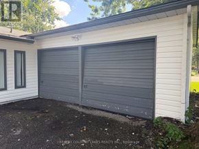 Ramara apartment for rent - A garage door of a house with a sign REMAX COUNTRY LAKES REALTY INC. Brokerage.