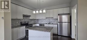 Milton (Ha Harrison) townhouse for rent - A kitchen with a refrigerator, stove, and cabinets.