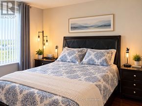 Richmond Hill (Langstaff) condo for rent - A bedroom with a large bed and a painting above it.