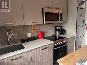 Toronto (The Beaches) condo for rent - A kitchen with a stove top oven and a microwave above it.