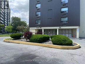 Toronto (Scarborough Village) condo for rent - A building with the number 5420 on it is surrounded by bushes.