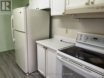 Toronto (Scarborough Village) condo for rent - A white refrigerator stands next to a white stove in a kitchen.