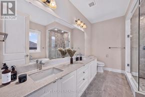 Richmond Hill apartment for rent - A bathroom with a large mirror, double sinks, and a walk-in shower.