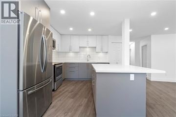 Burlington apartment for rent - A modern kitchen with a stainless steel refrigerator and wooden flooring.