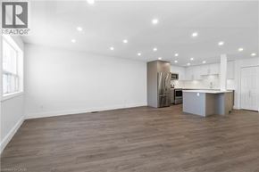 Burlington apartment for rent - A spacious kitchen with a refrigerator, sink, and cabinets.