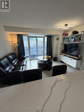 Toronto (Church-Yonge Corridor) condo for rent - A living room with a black leather couch and a television.