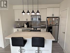 Toronto (Church-Yonge Corridor) condo for rent - A kitchen with a white island and black barstools.